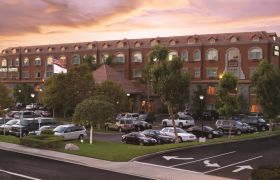 Front exterior of Ayres Suites Yorba Linda with cars in front