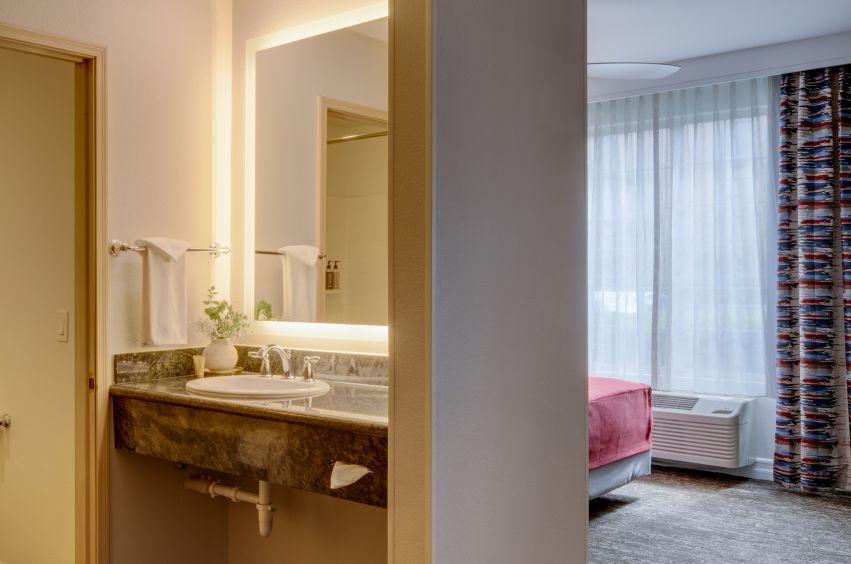 A Bathroom With A Large Mirror