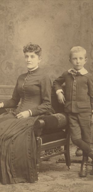 Ayres Family members posing sitting in a chair and standing next to the chair 