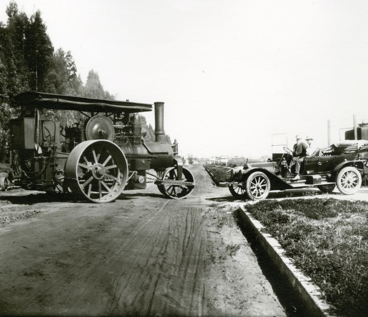 A work truck and car working on the road