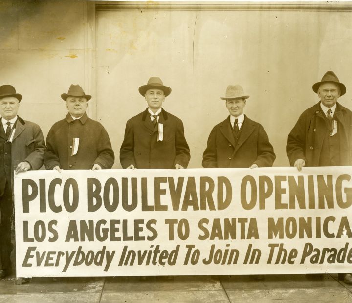 Pico Boulevard Opening sign with 5 men in the background 