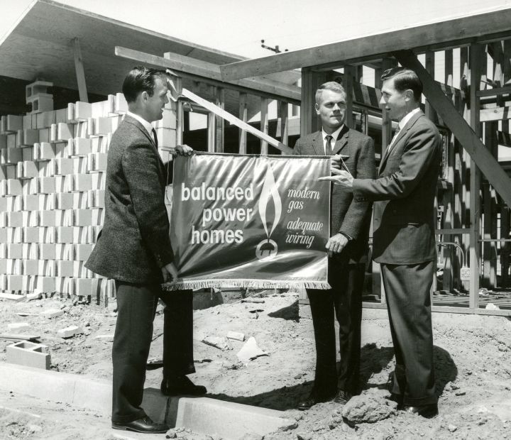 Ayres Family holding a balanced power homes sign