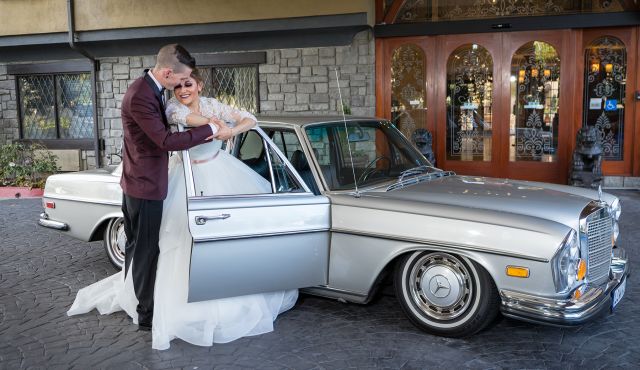 Bride and Groom Posing Next to a Car