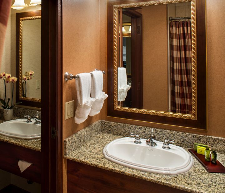 A Hotel Room With A Sink And A Mirror