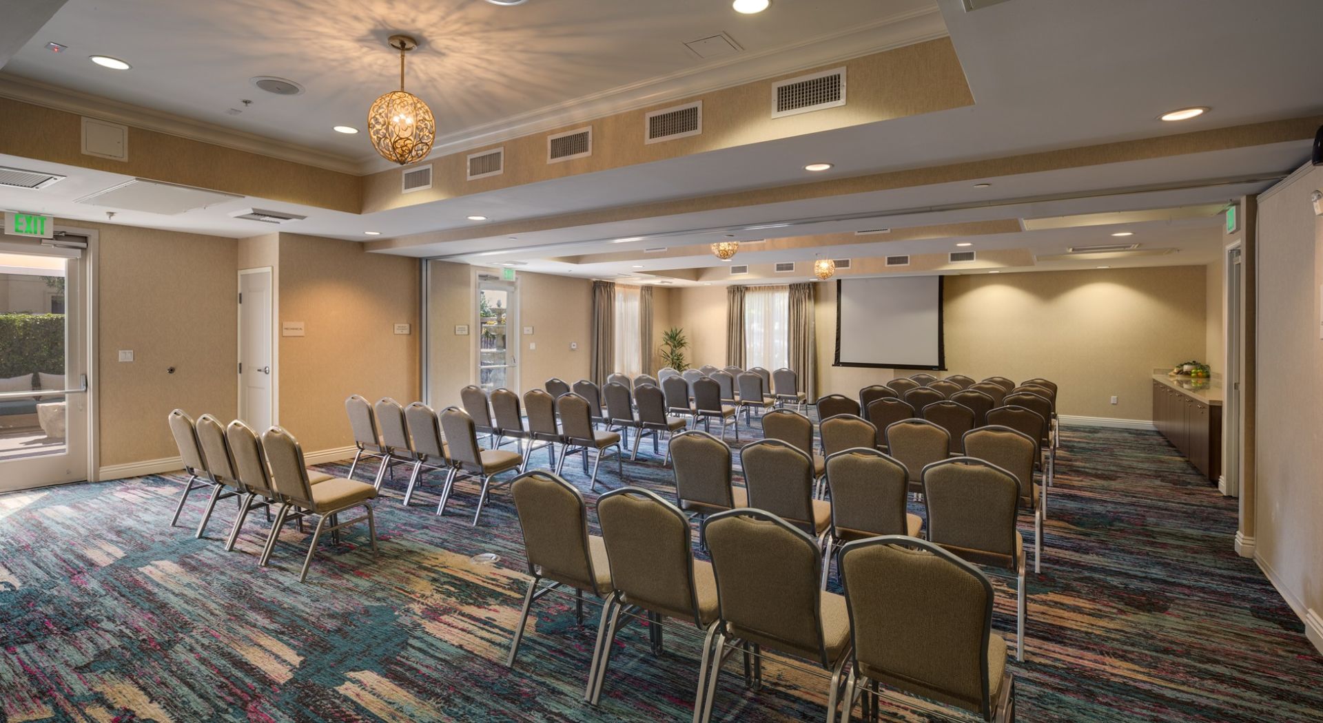 A Room With A Large Group Of Chairs And A Projector Screen
