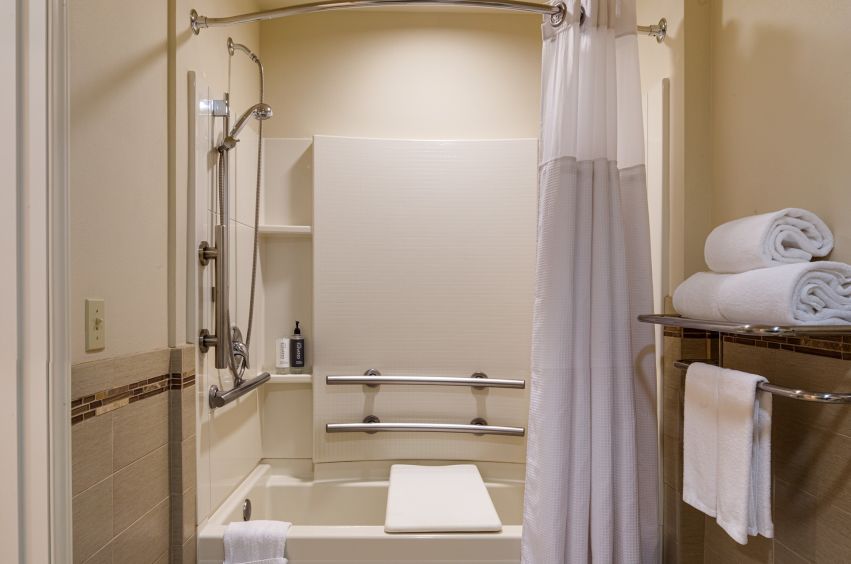 A Bathroom With A Shower And Towels